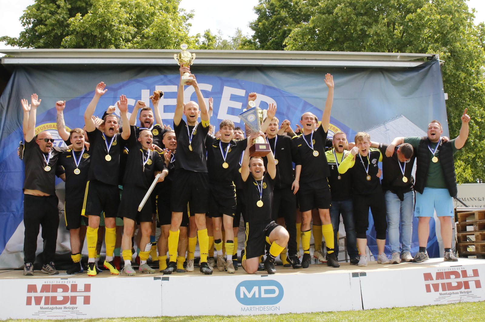 Herrenmannschaft des Neuburger SV feiert den Kreispokalsieg mit dem Pokal
